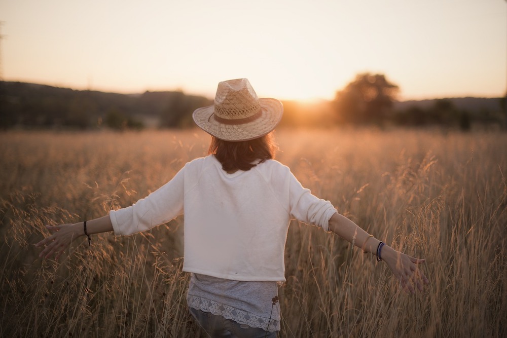femme avec un chapeau marchant librement dans un champs de blé thérapie de couple
