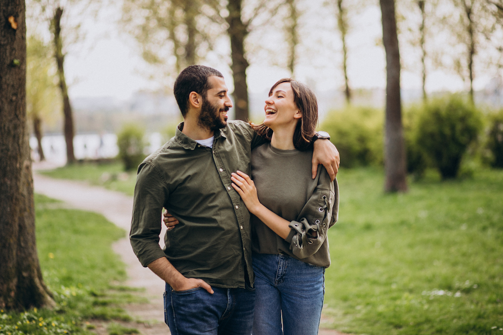 couple heureux enlacé qui se regarde et sourit dans une forêt thérapie